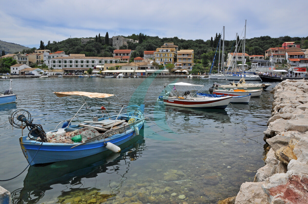 Fischerboote und Segelyachten im Hafen von Kassiopi unter der Burg